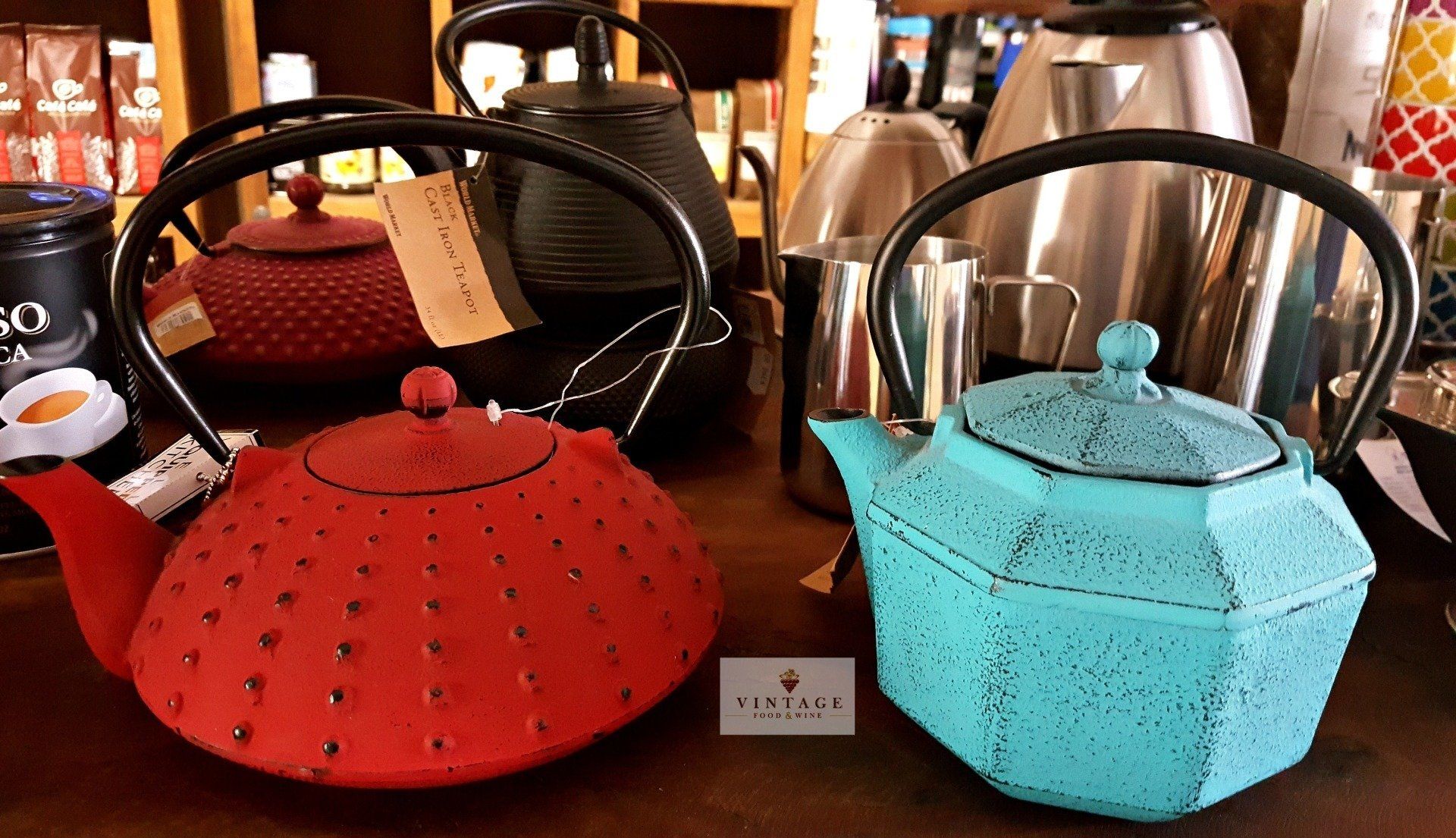 Una tetera roja y una tetera azul están sobre una mesa.