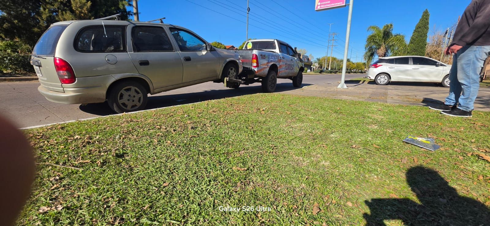 Un SUV y un sedán estacionados junto a una franja de césped