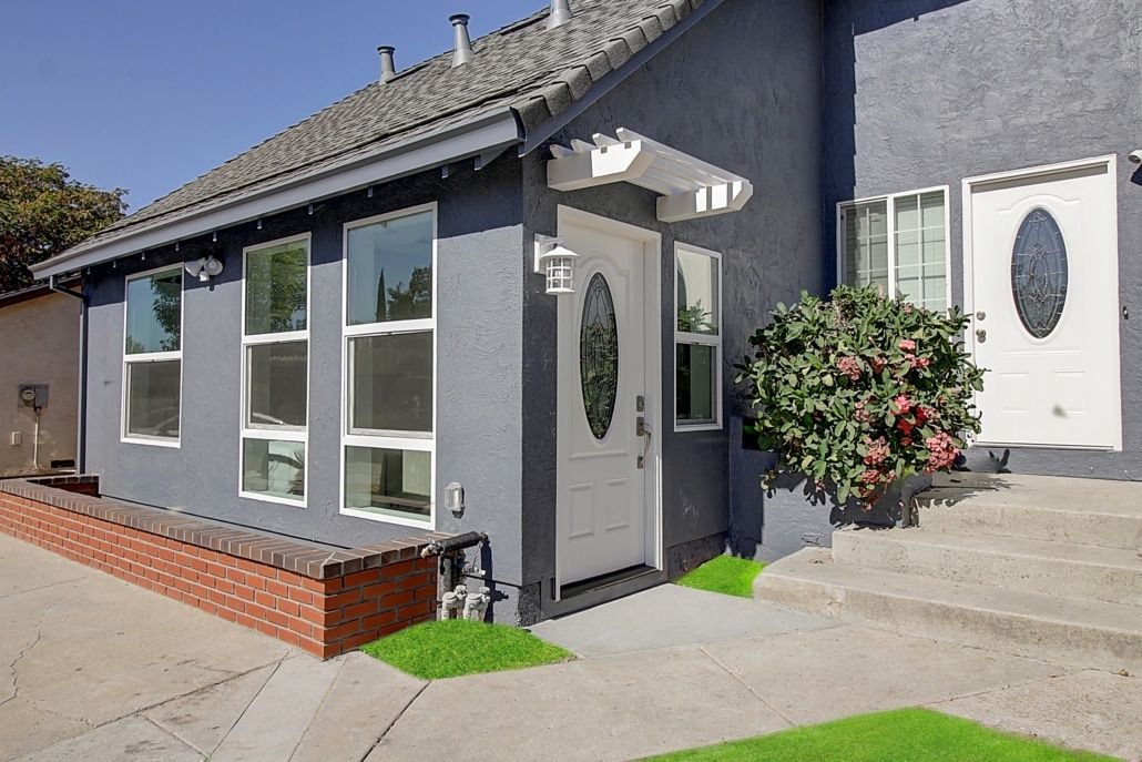 A gray house with a white door and windows