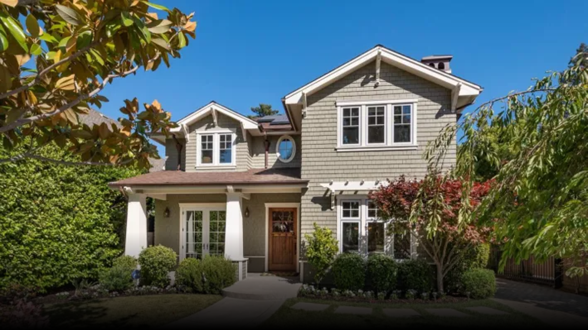 A large house with a lot of windows and trees in front of it.