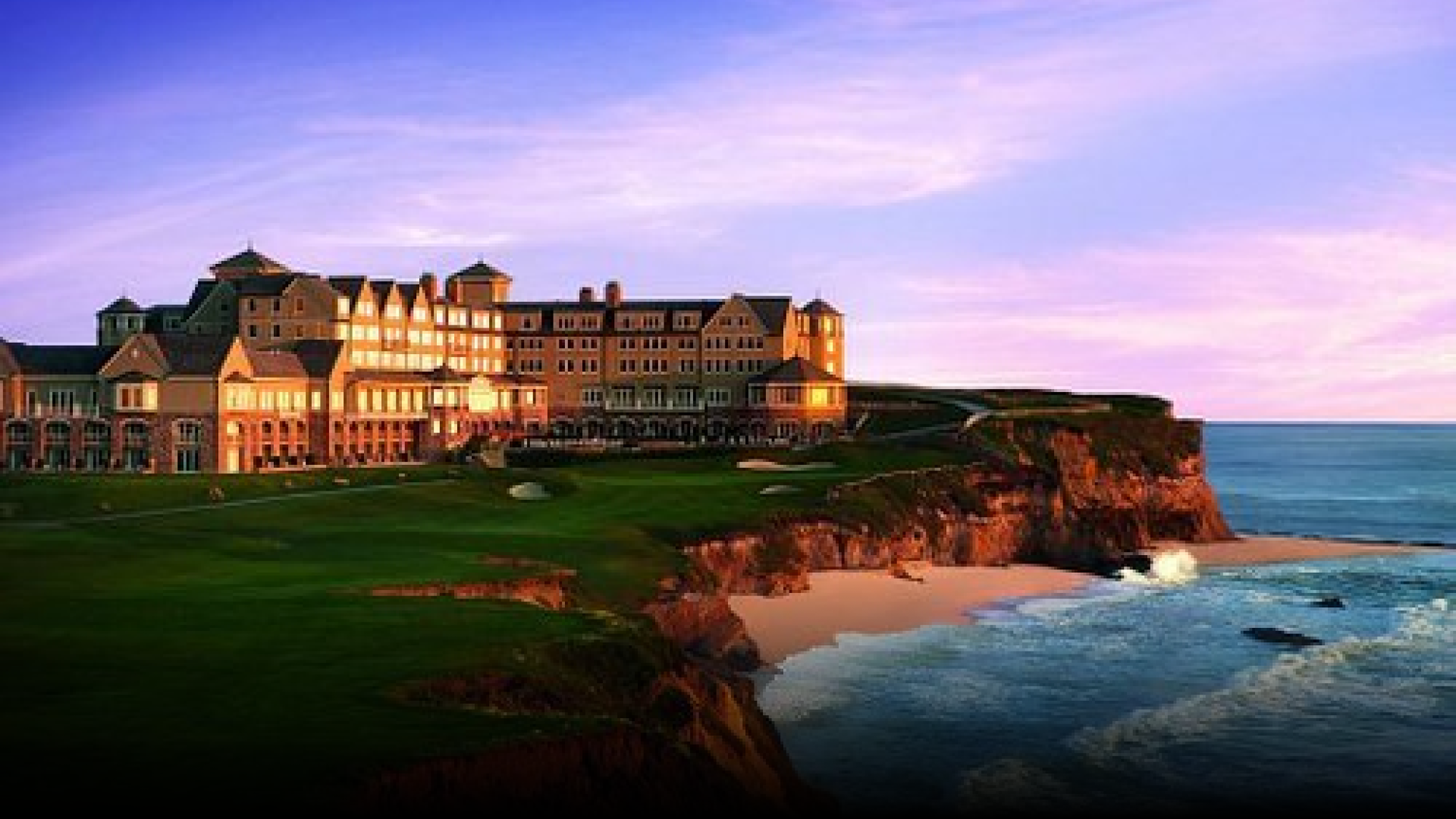 A large building is sitting on top of a cliff overlooking the ocean.
