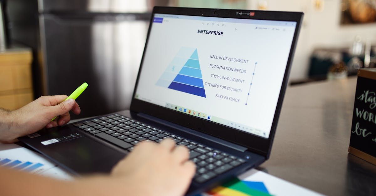 A person is using a laptop computer with a pyramid on the screen.