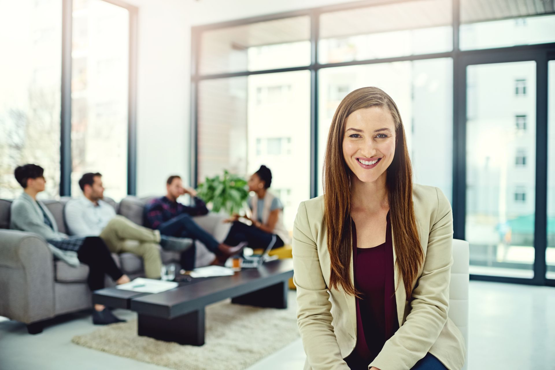 A woman is sitting in a chair in front of a group of people.