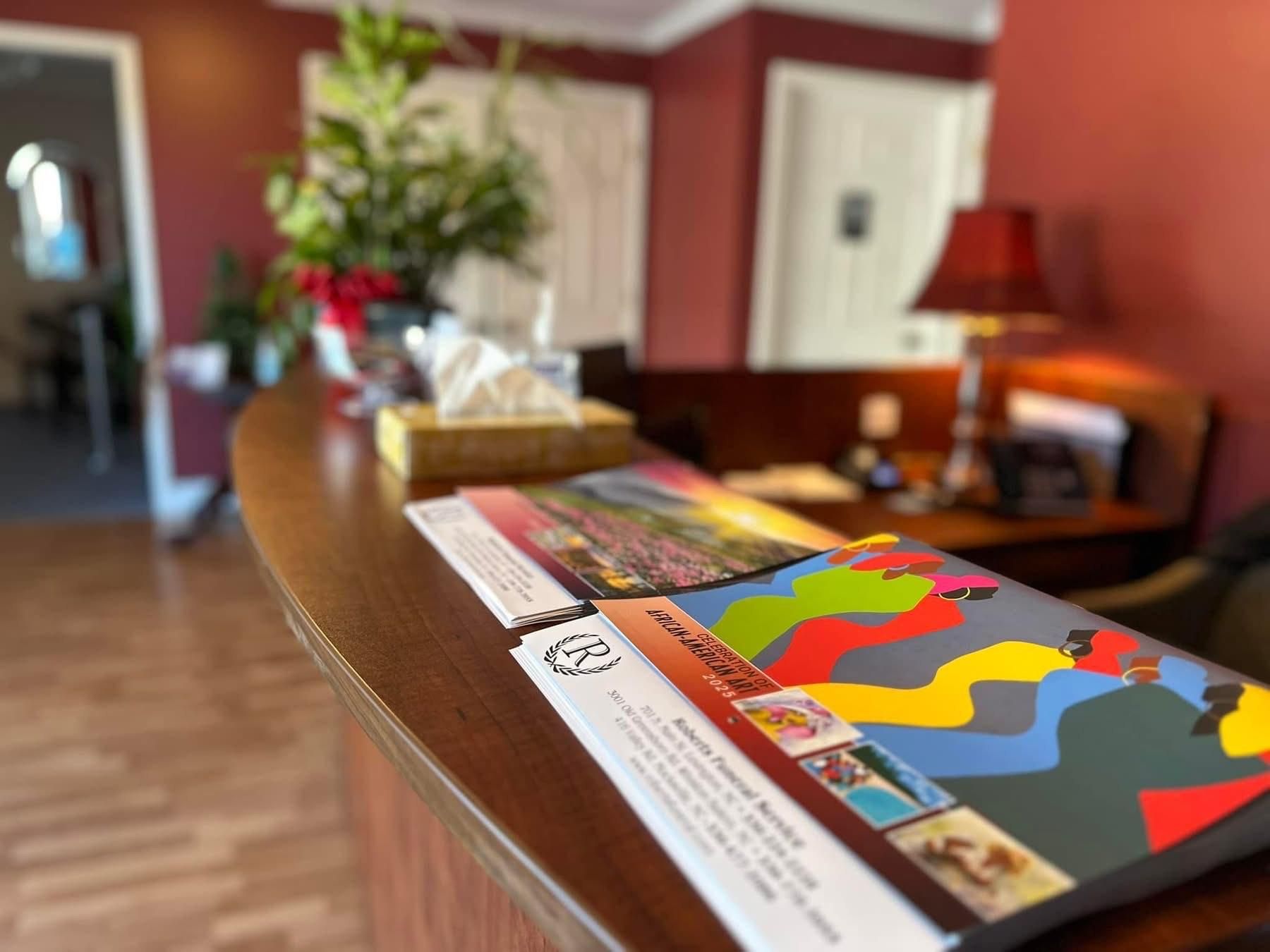 Reception desk with brochures, tissue box, and lamp. Red wall backdrop.