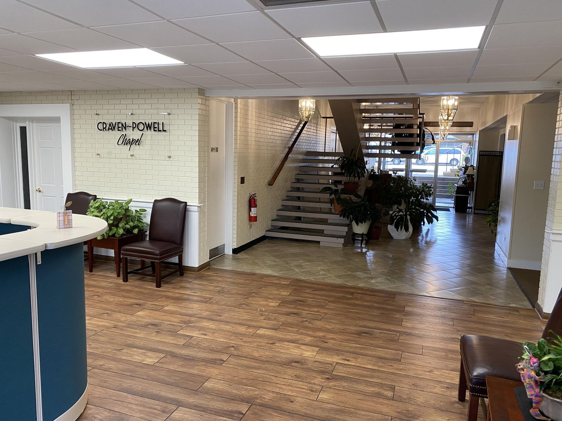 Interior lobby with wooden floors, staircase, and reception desk.  