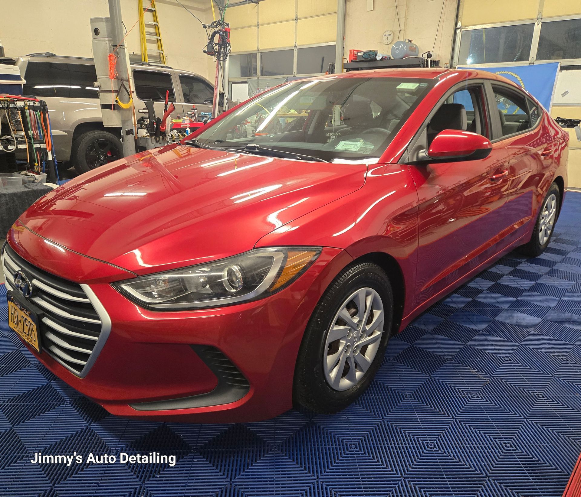 A red hyundai elantra is parked in a garage.