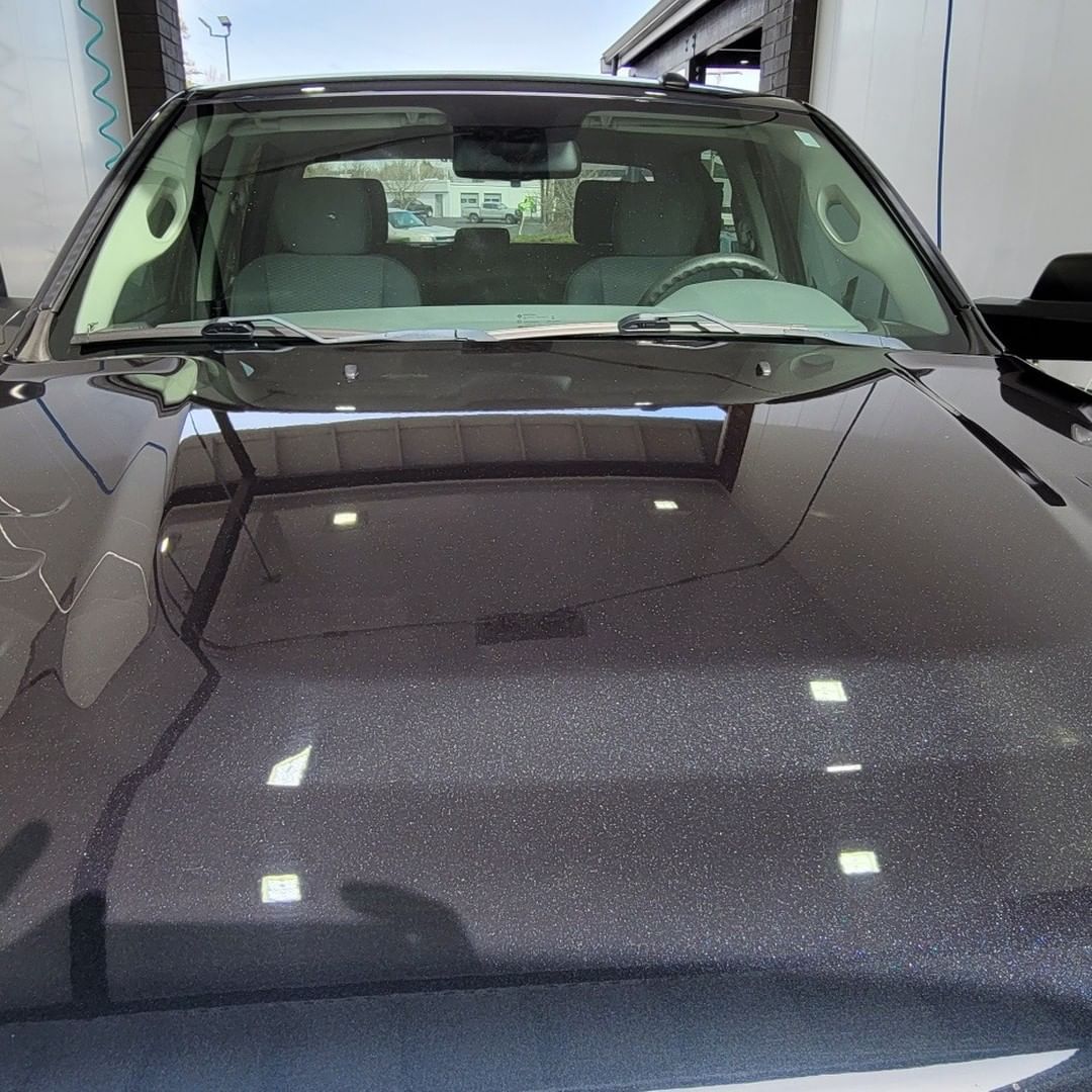 A black car is parked in front of a building