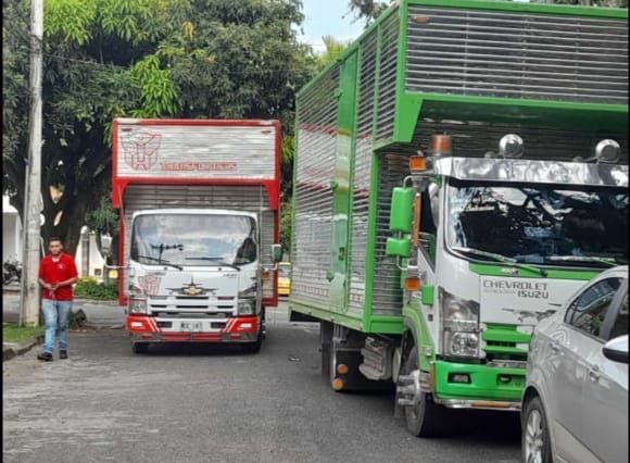 Un par de camiones están estacionados al costado de la carretera.
