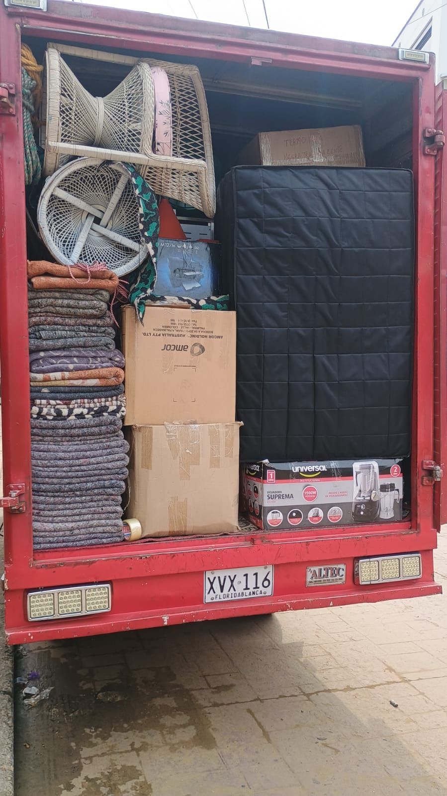 Dos hombres están cargando un sofá en una furgoneta.