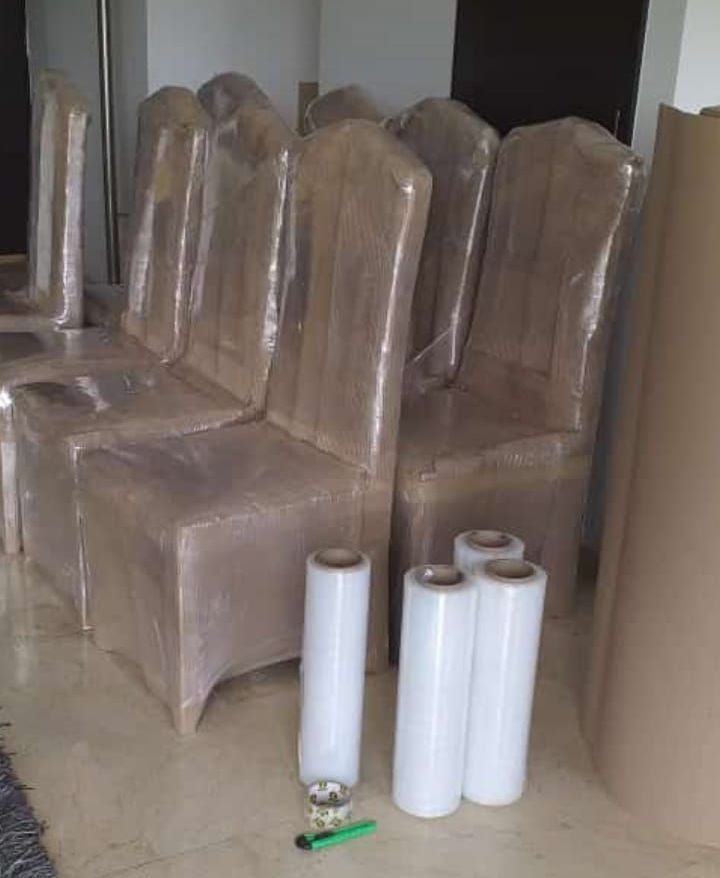 Un hombre está pegando una caja de cartón con cinta adhesiva.