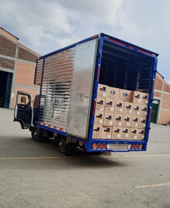 Un camión azul lleno de cajas está estacionado en un estacionamiento