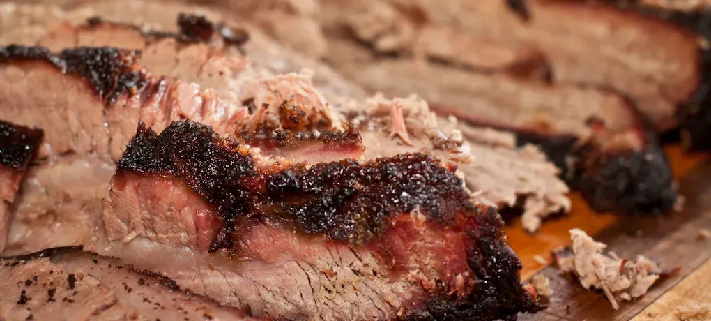 Sliced brisket with a dark, crusty bark and juicy, pink interior.