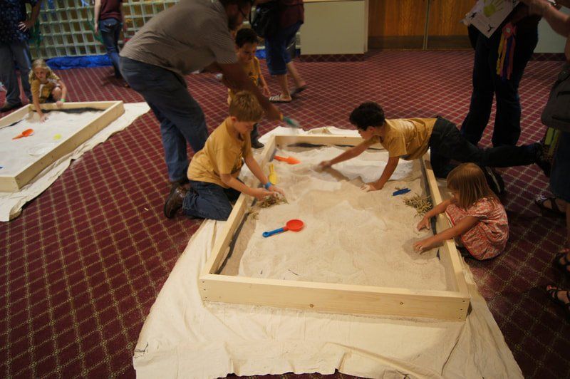 kids digging in sandbox for dino bones