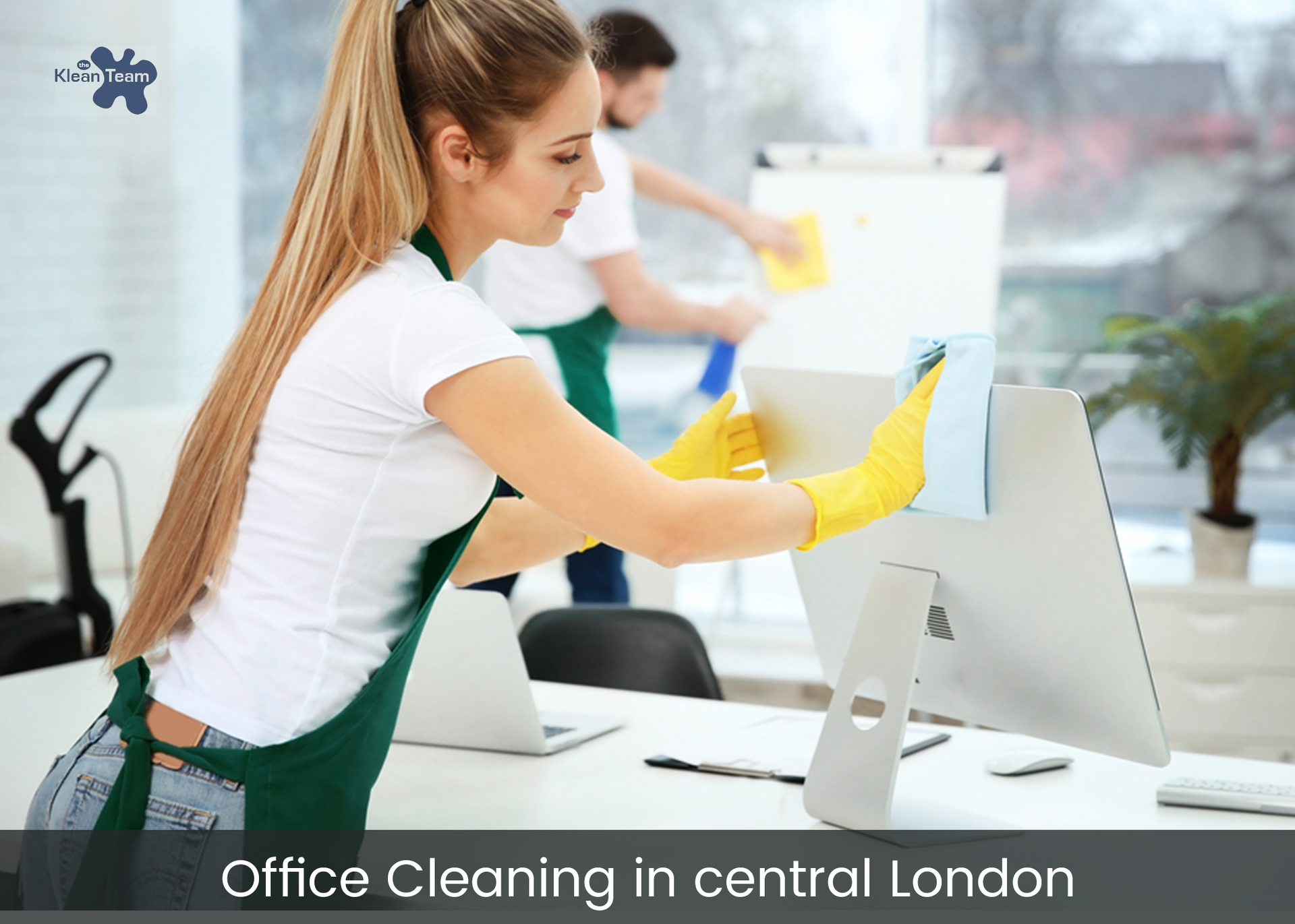 A woman is cleaning a computer monitor in an office.