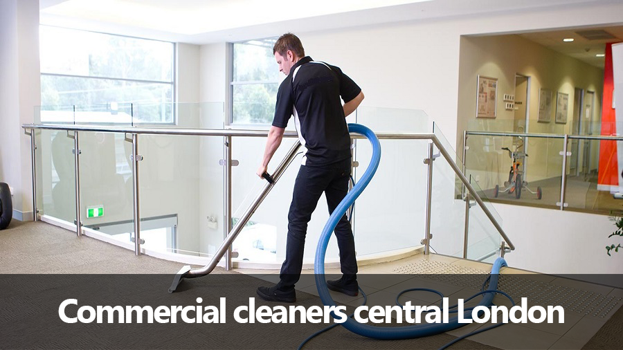 A man is using a vacuum cleaner to clean the floor of a building.