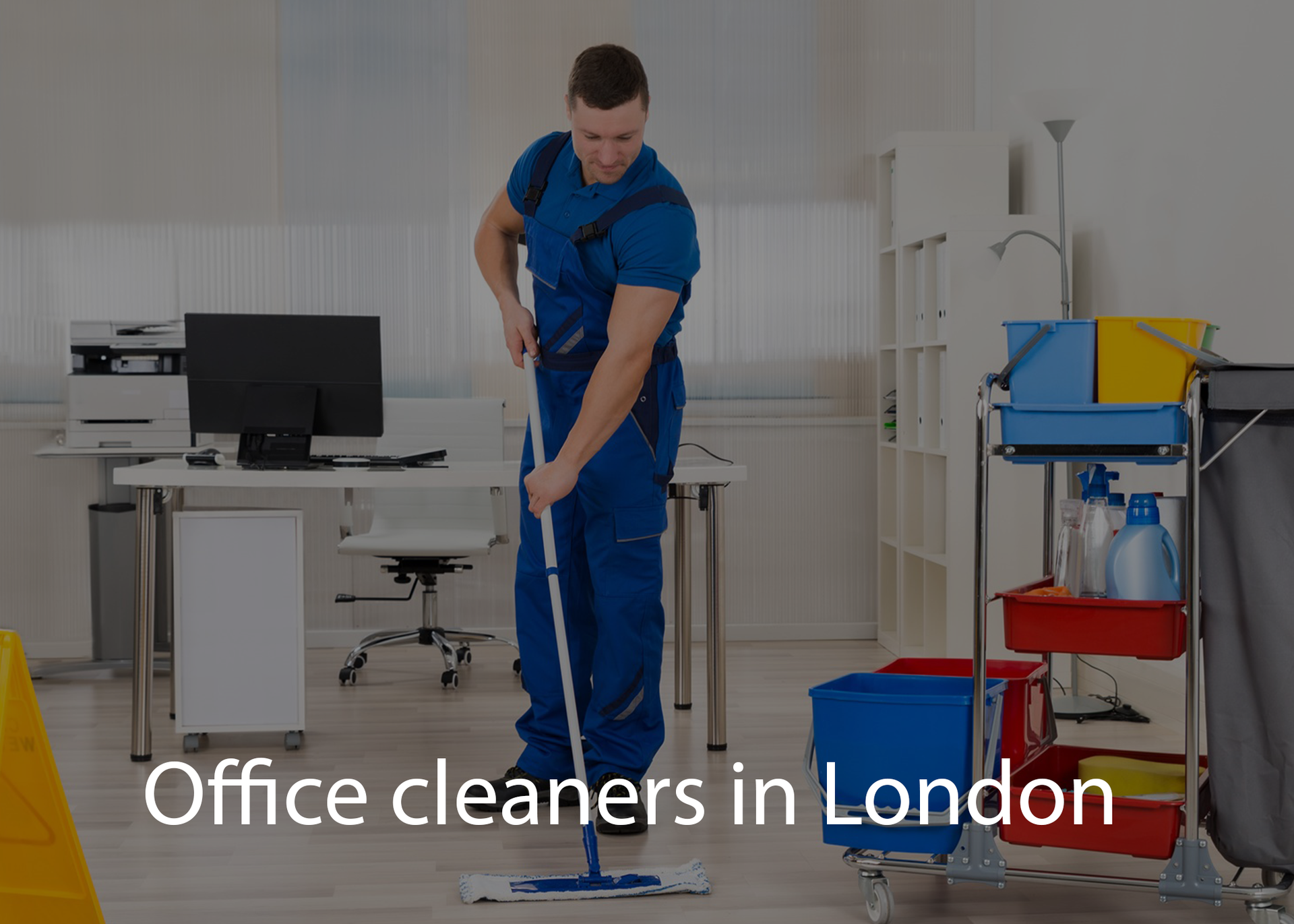 A man is cleaning the floor of an office with a mop.