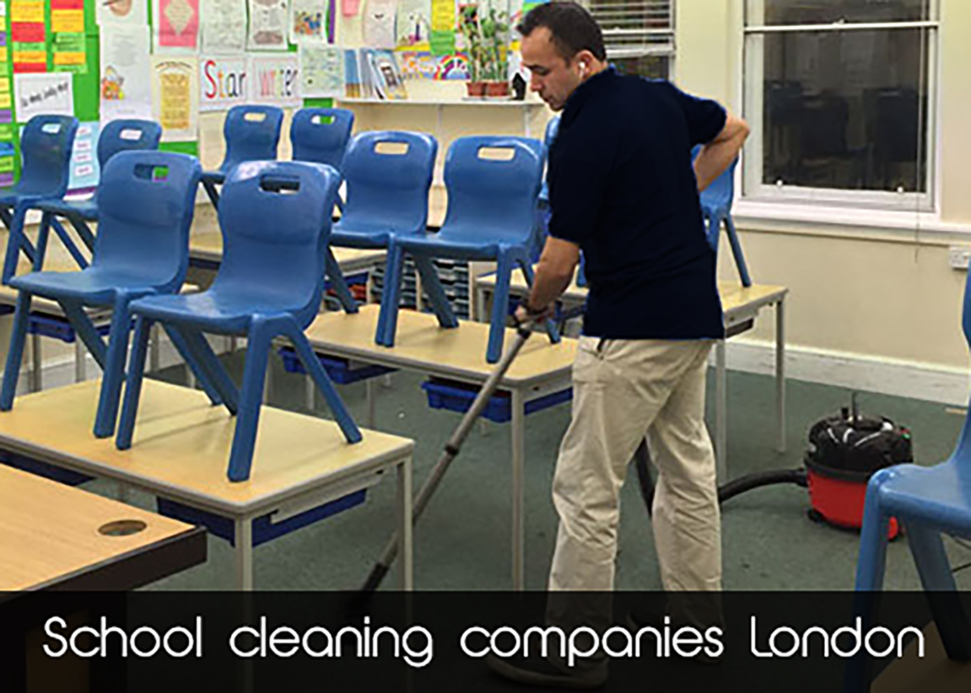 A man is cleaning a classroom with a vacuum cleaner ..