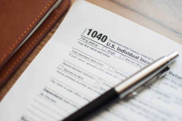 A pen is sitting on top of a 1040 us individual income tax form