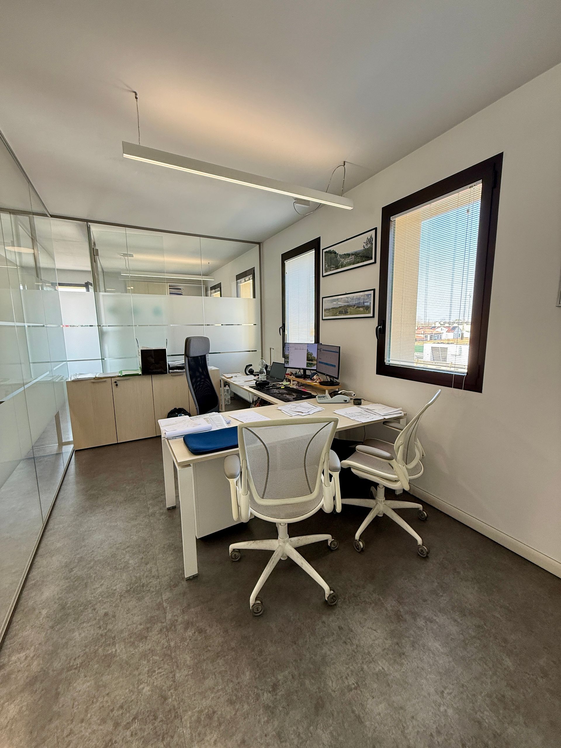 Una stanza con una scrivania, delle sedie e una finestra.