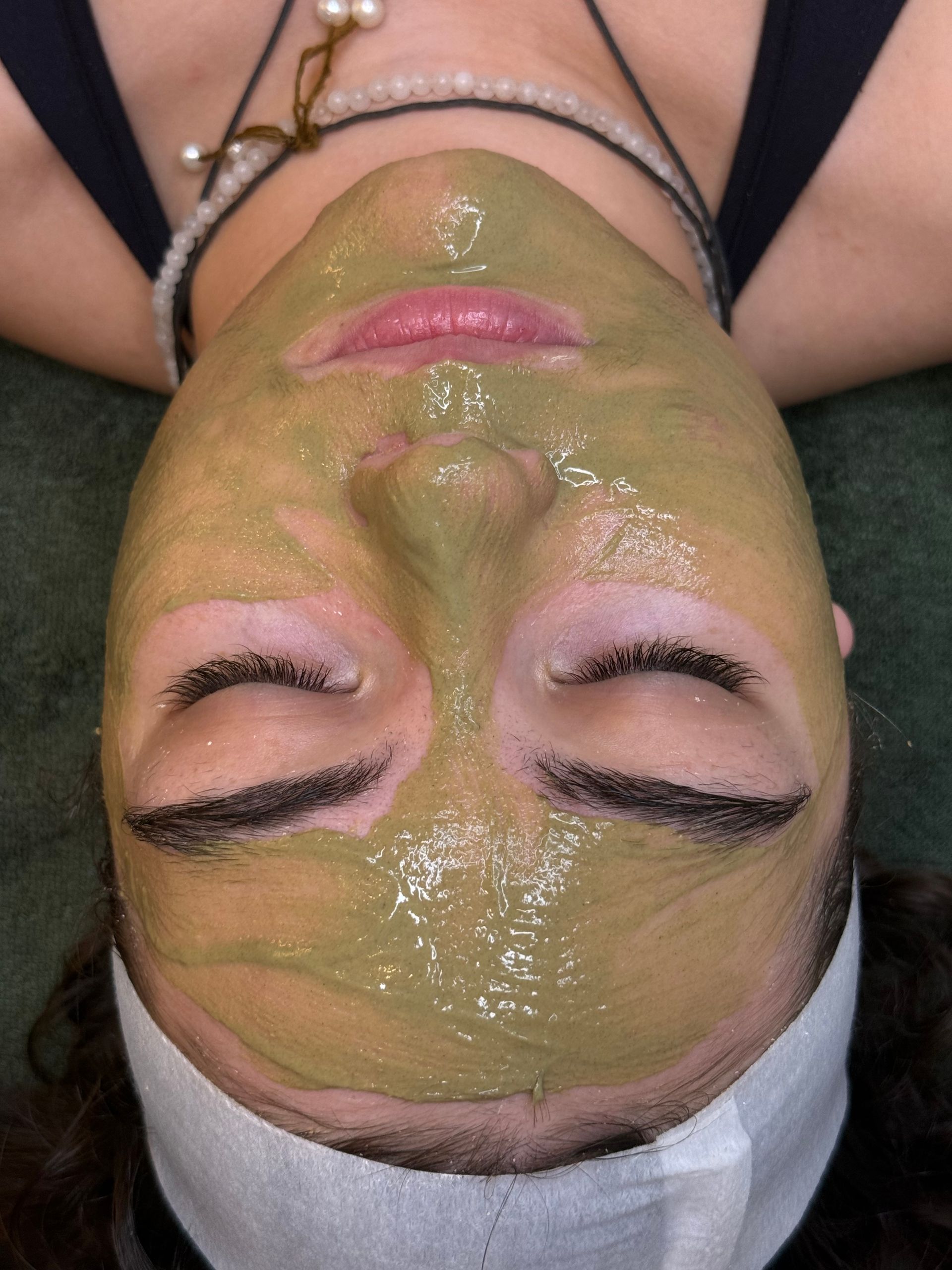 A person with closed eyes, fair skin, and freckles. Light tan skin with light lip color.