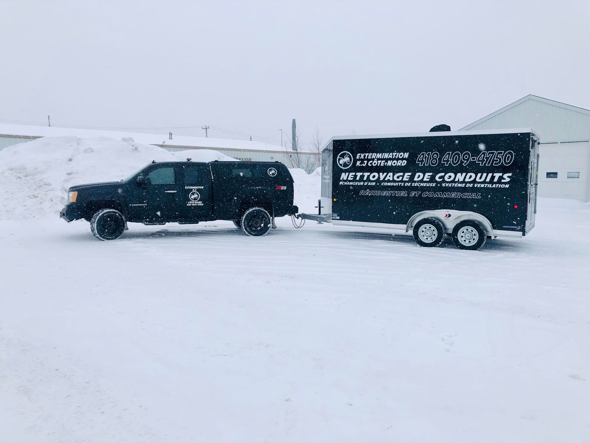Un camion tire une remorque dans la neige.