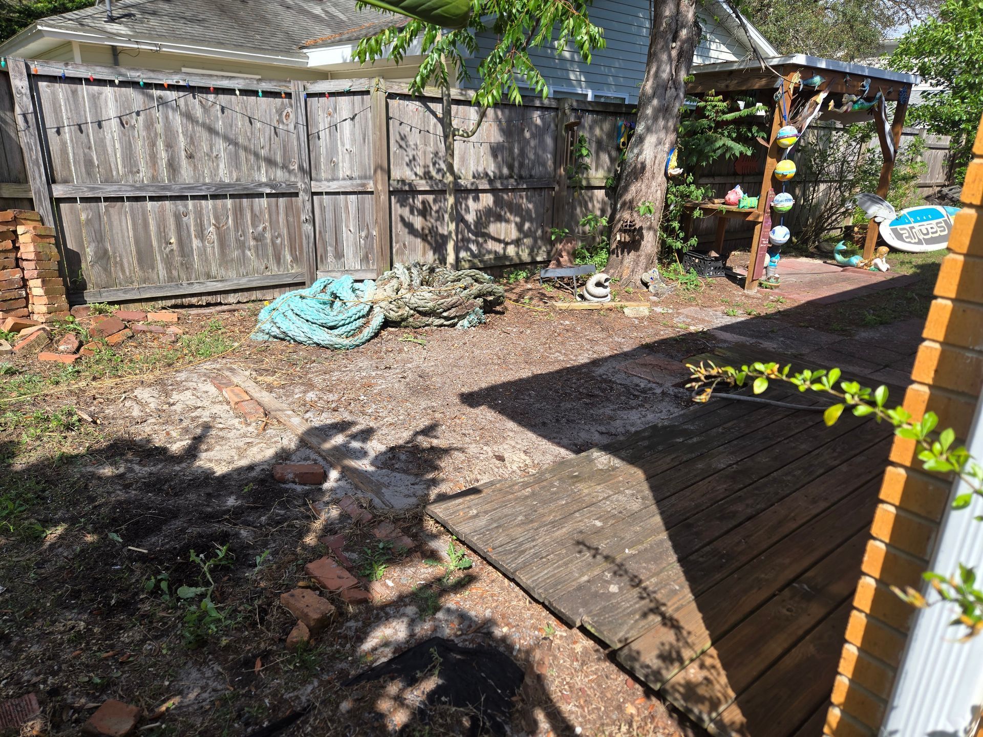 A backyard with a wooden fence and a wooden deck.