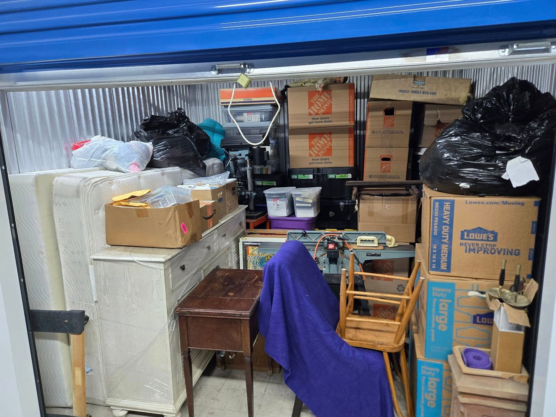 A storage unit filled with lots of boxes and furniture.