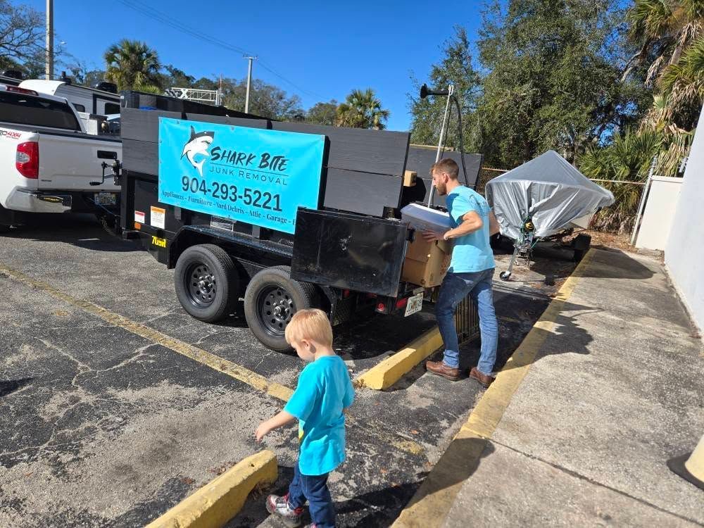 A man and a little boy are standing in front of a trailer that says sunny bay.