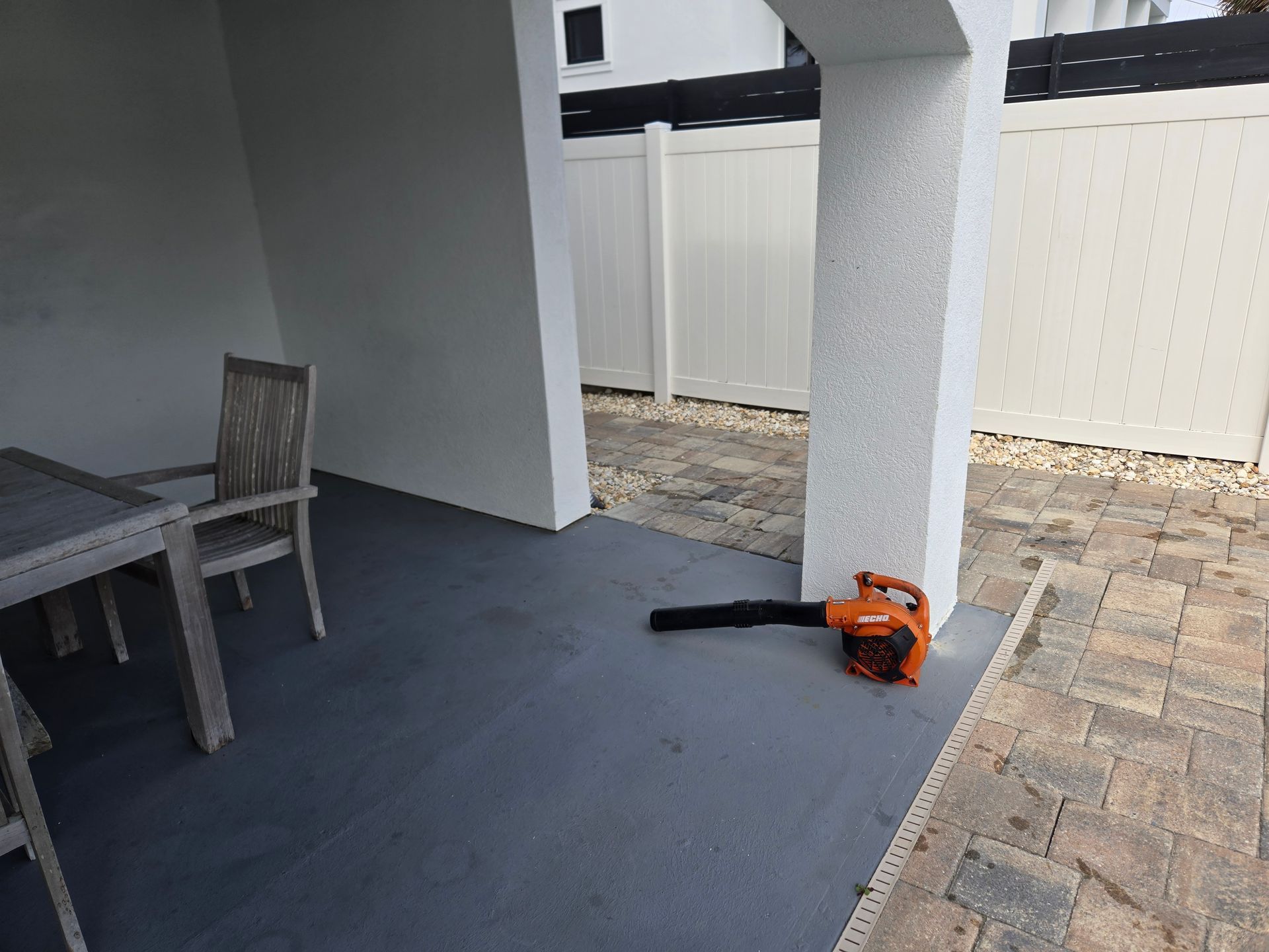A blower is sitting on a patio next to a table and chairs.