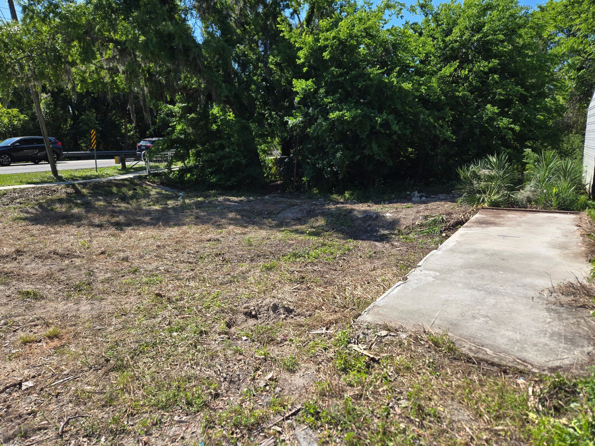 There is a concrete walkway in the middle of a dirt field.