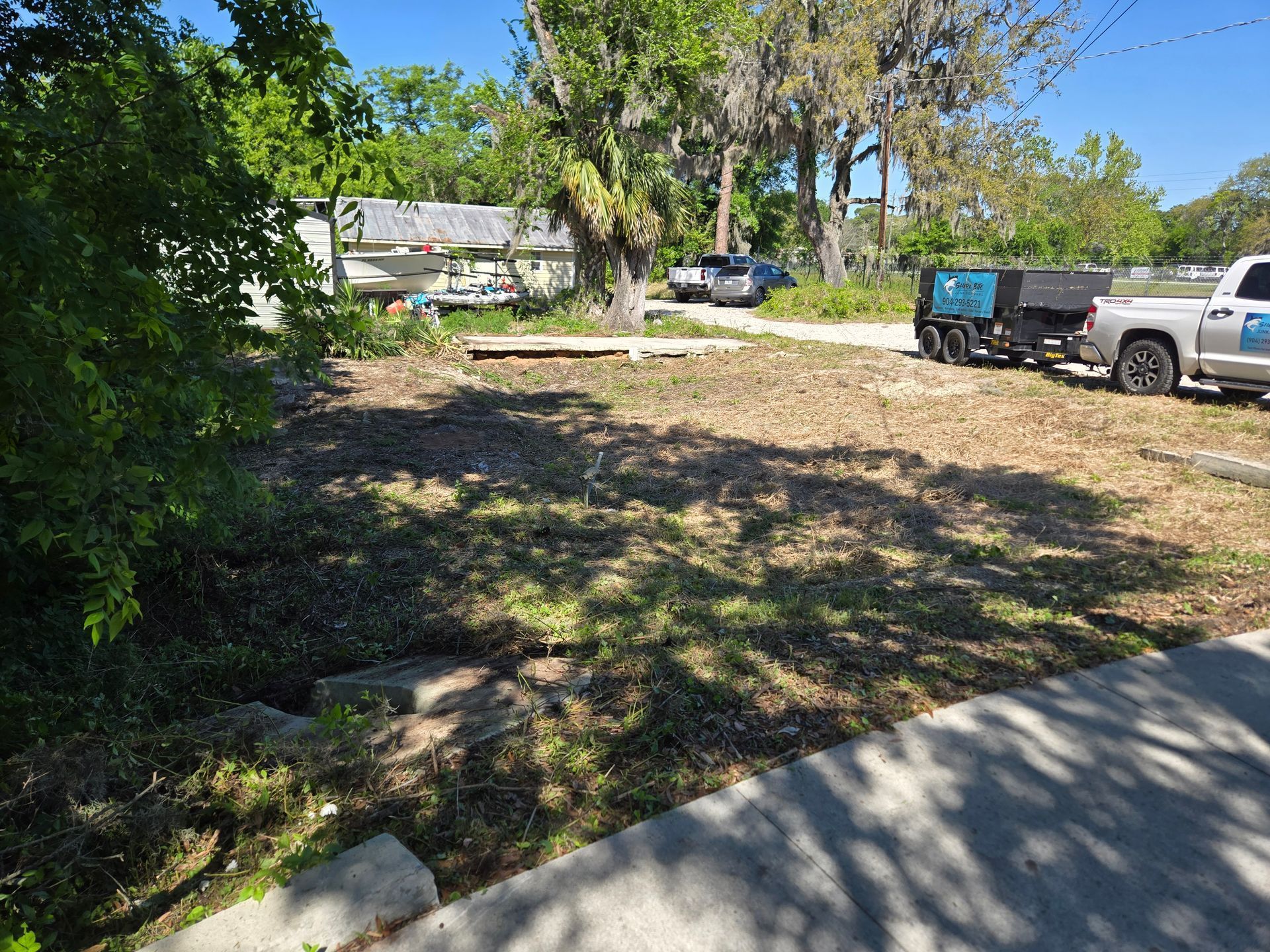 A truck is parked on the side of the road in a yard.