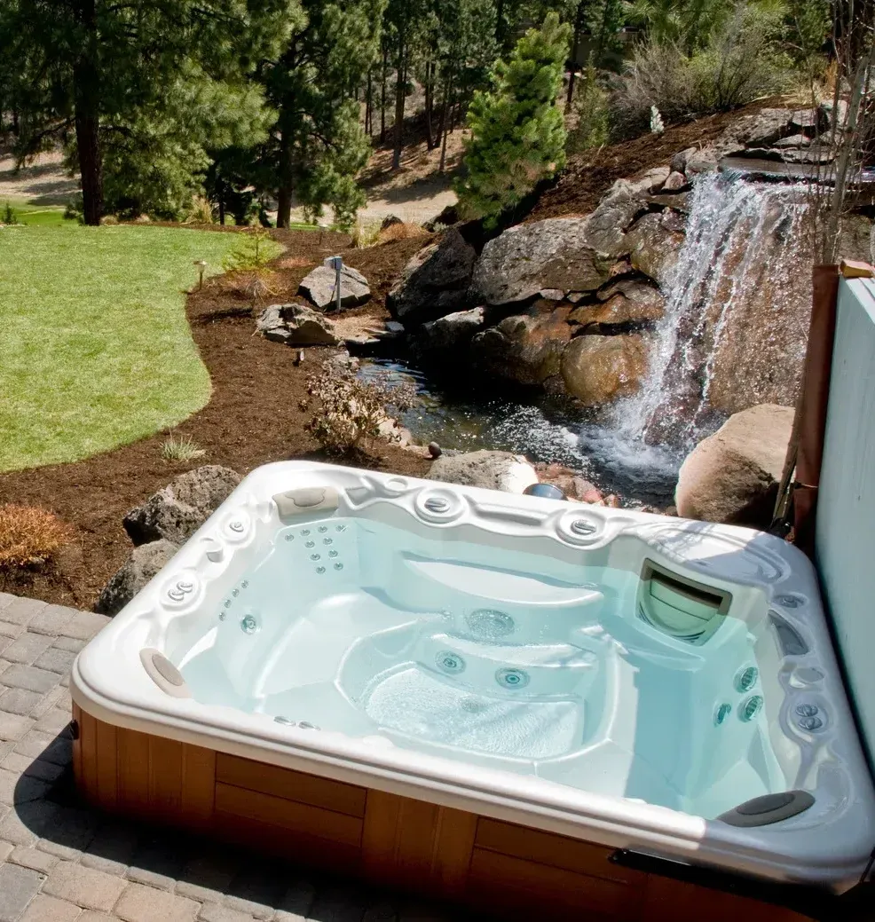A hot tub with a waterfall in the background