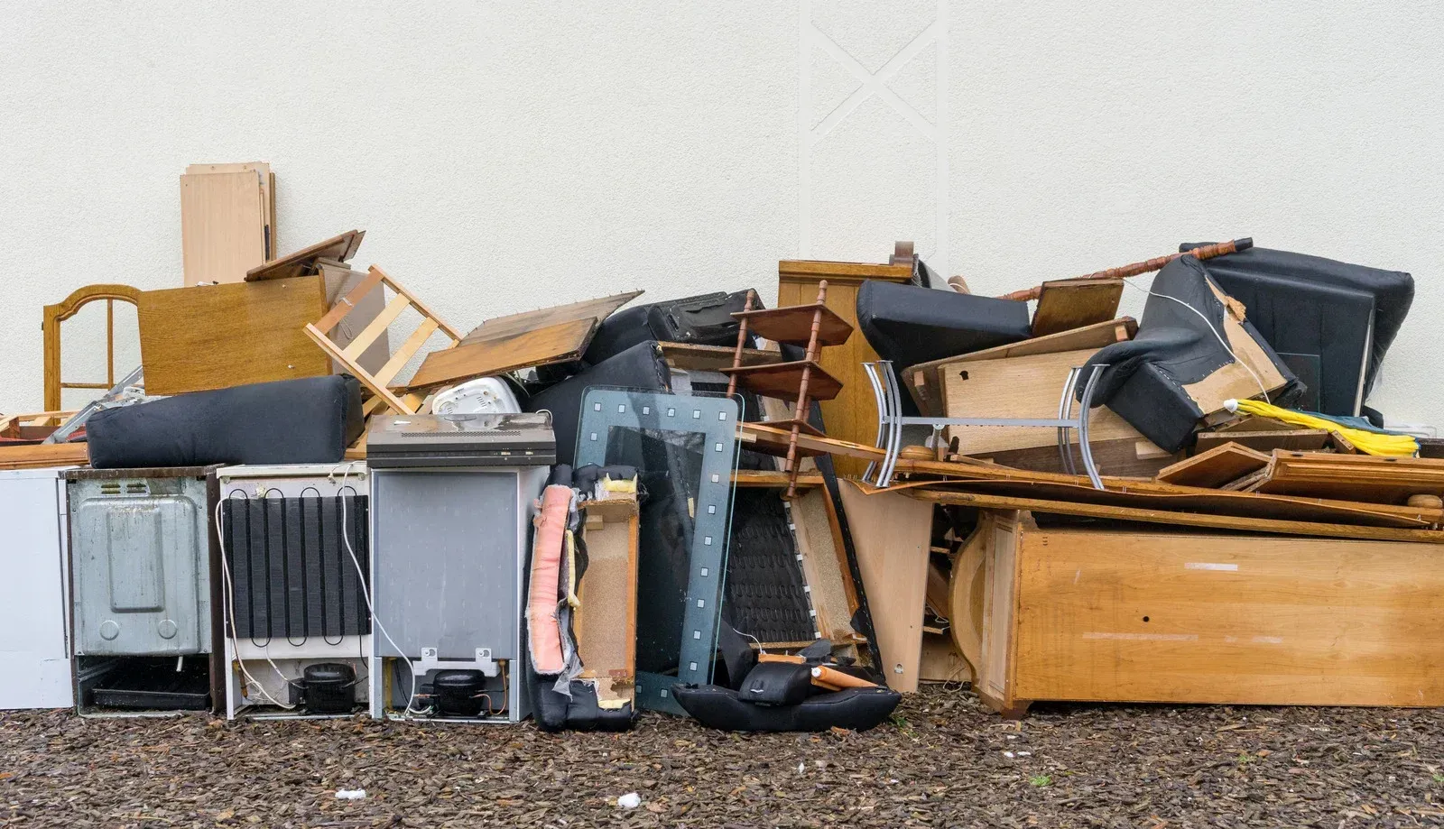 A pile of junk is sitting on the ground in front of a building.