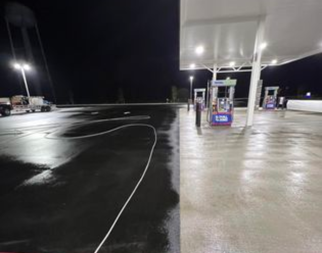 A gas station at night with a few pumps