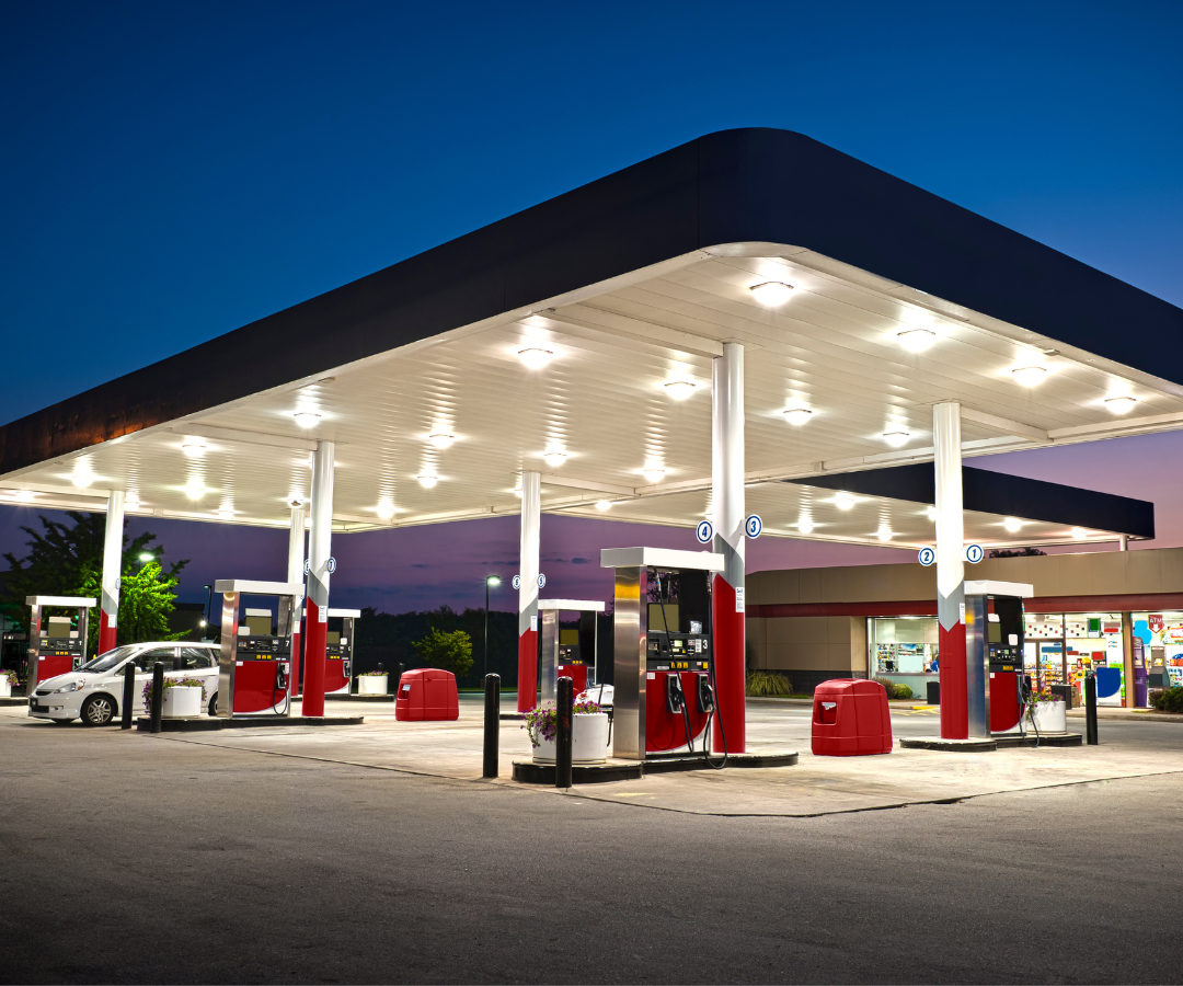 A gas station with cars parked in front of it at night