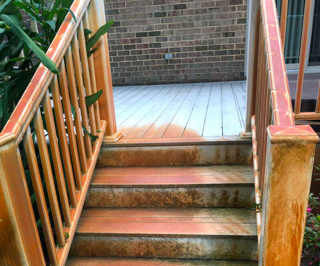 A set of stairs leading up to a deck with a wooden railing.