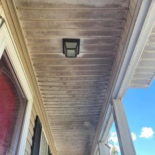 The ceiling of a porch with a light on it.