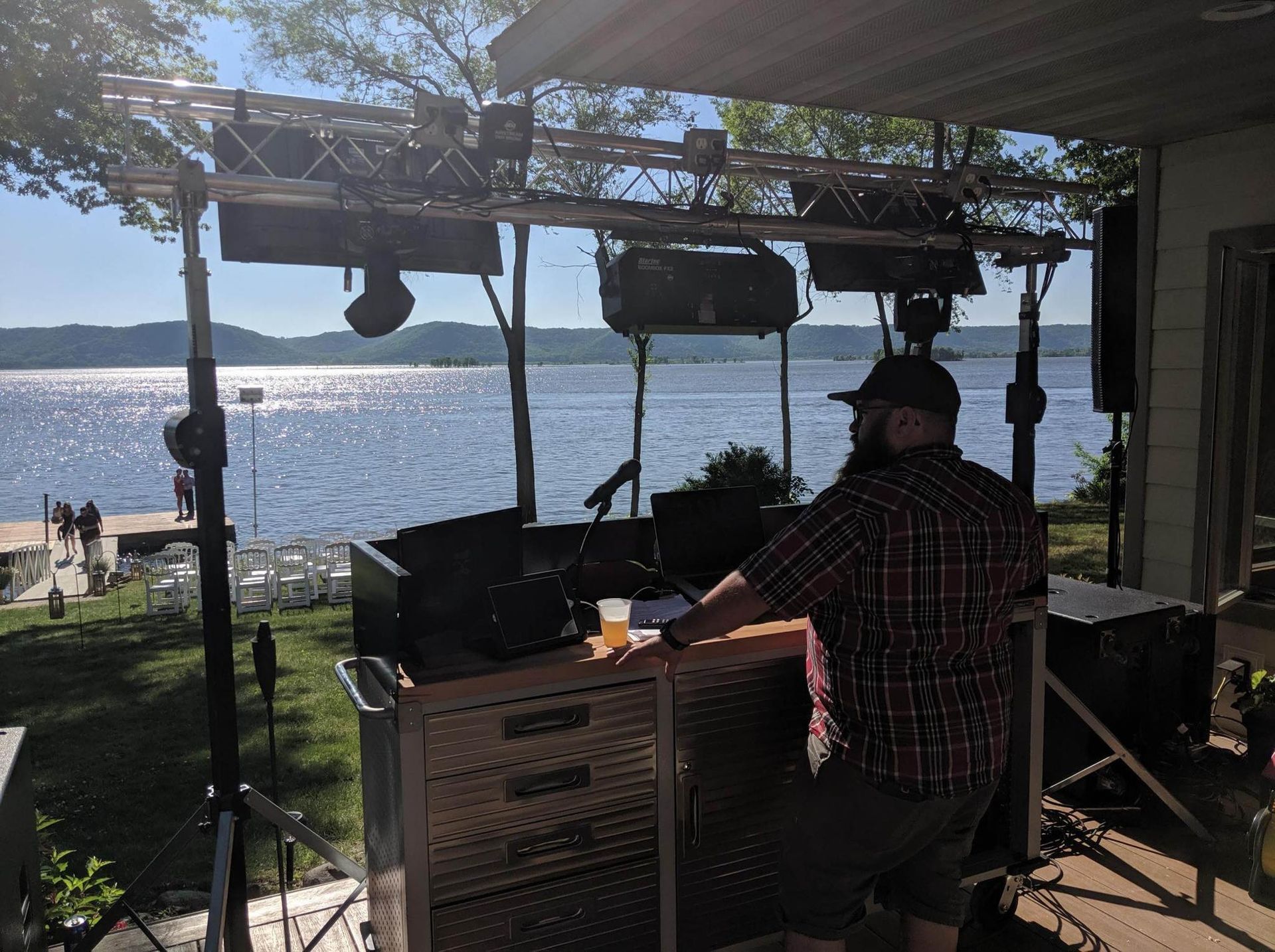 A man is sitting at a table in front of a large body of water.