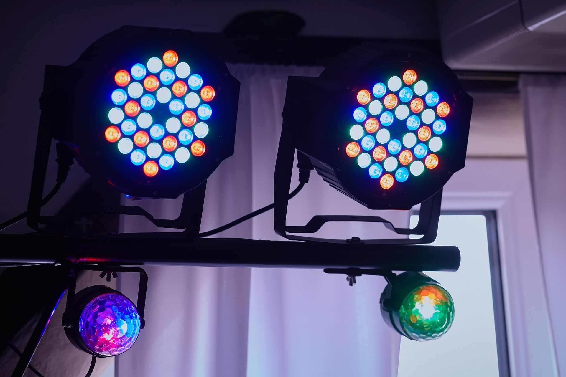 A photo booth is sitting in front of a wall with red and yellow lights.