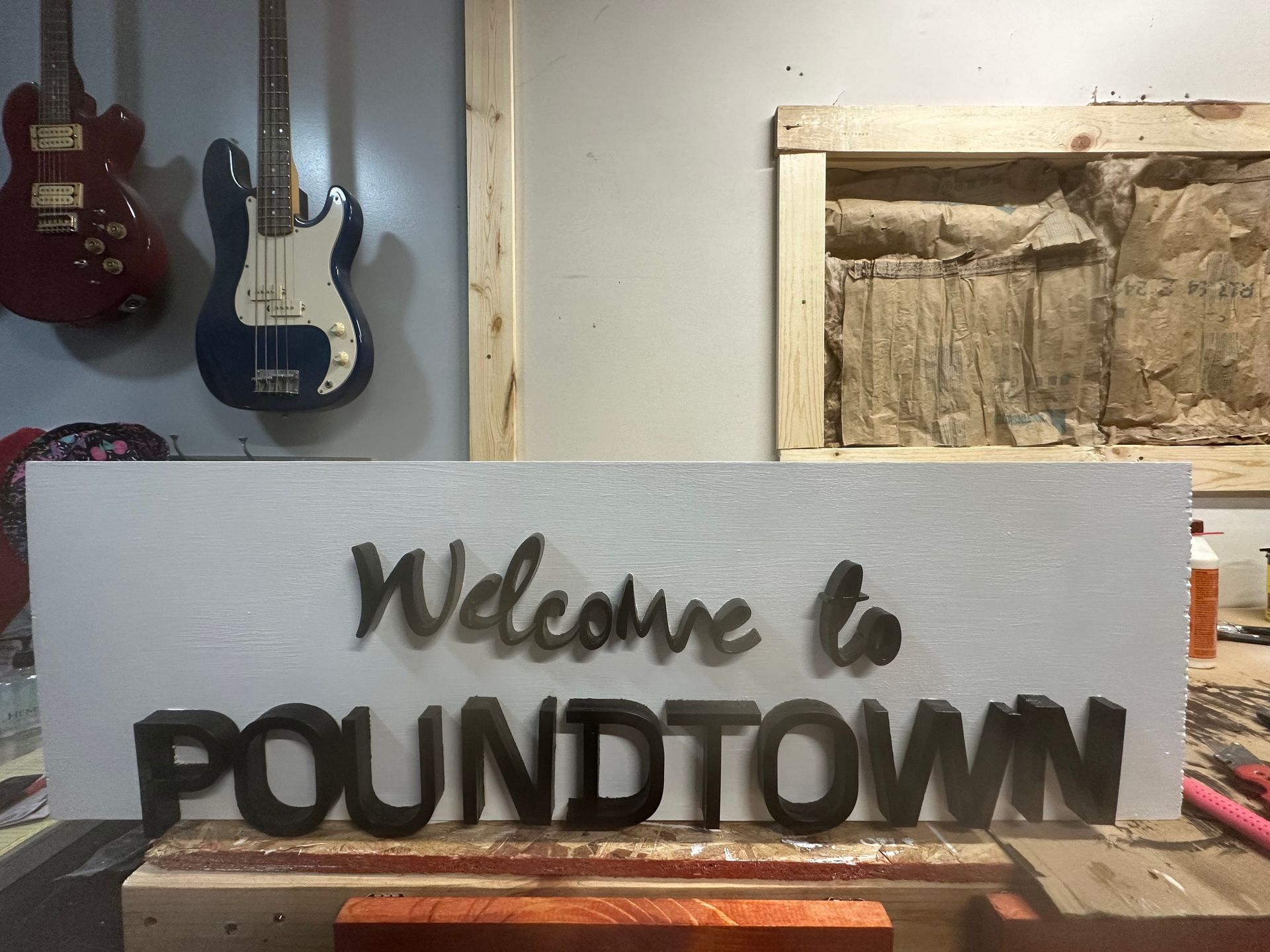 A welcome to poundtown sign is sitting on a wooden table.