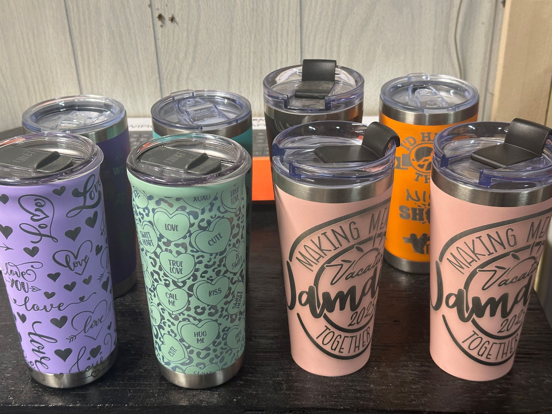 A group of stainless steel tumblers are sitting on a table.