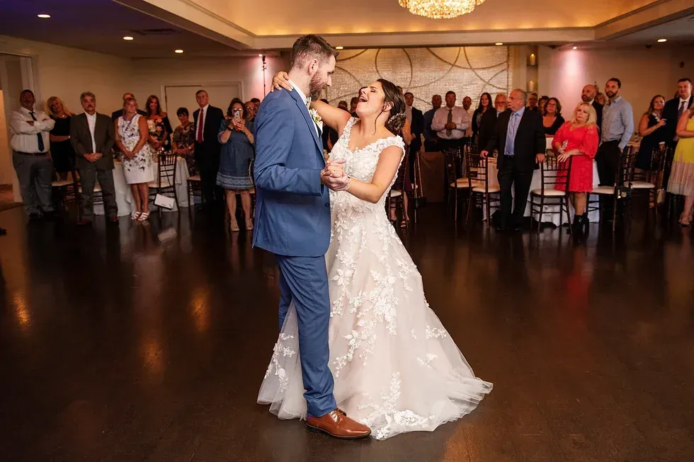 A bride and groom are dancing their first dance at their wedding reception.