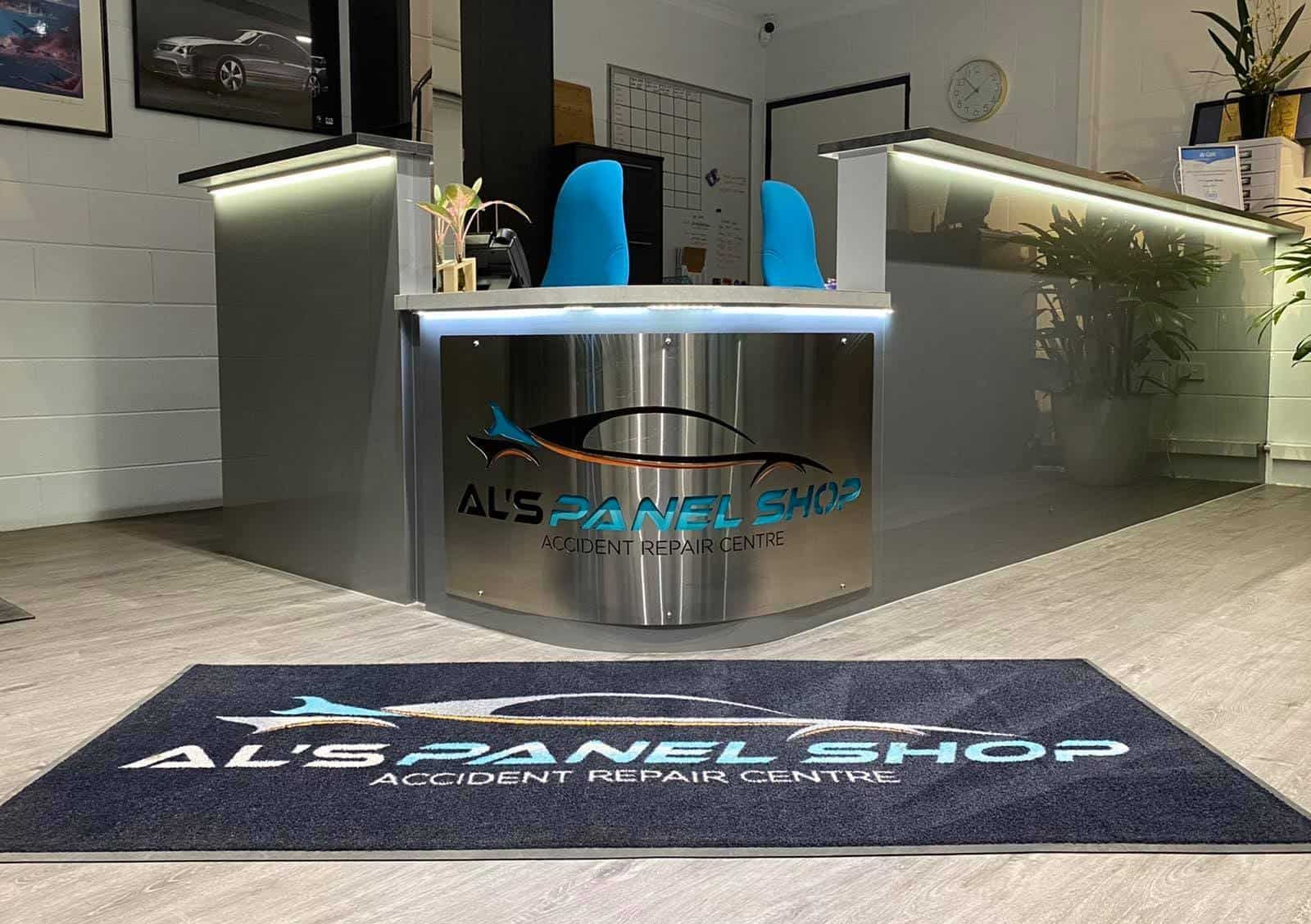 Reception Area of Al's Panel Shop, with A Silver Desk, Blue Chairs, and A Welcome Mat — Al's Panel Shop in Berrimah, NT