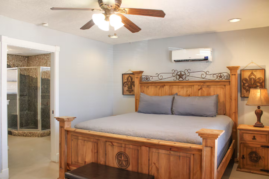 A bedroom with a king size bed and a ceiling fan.