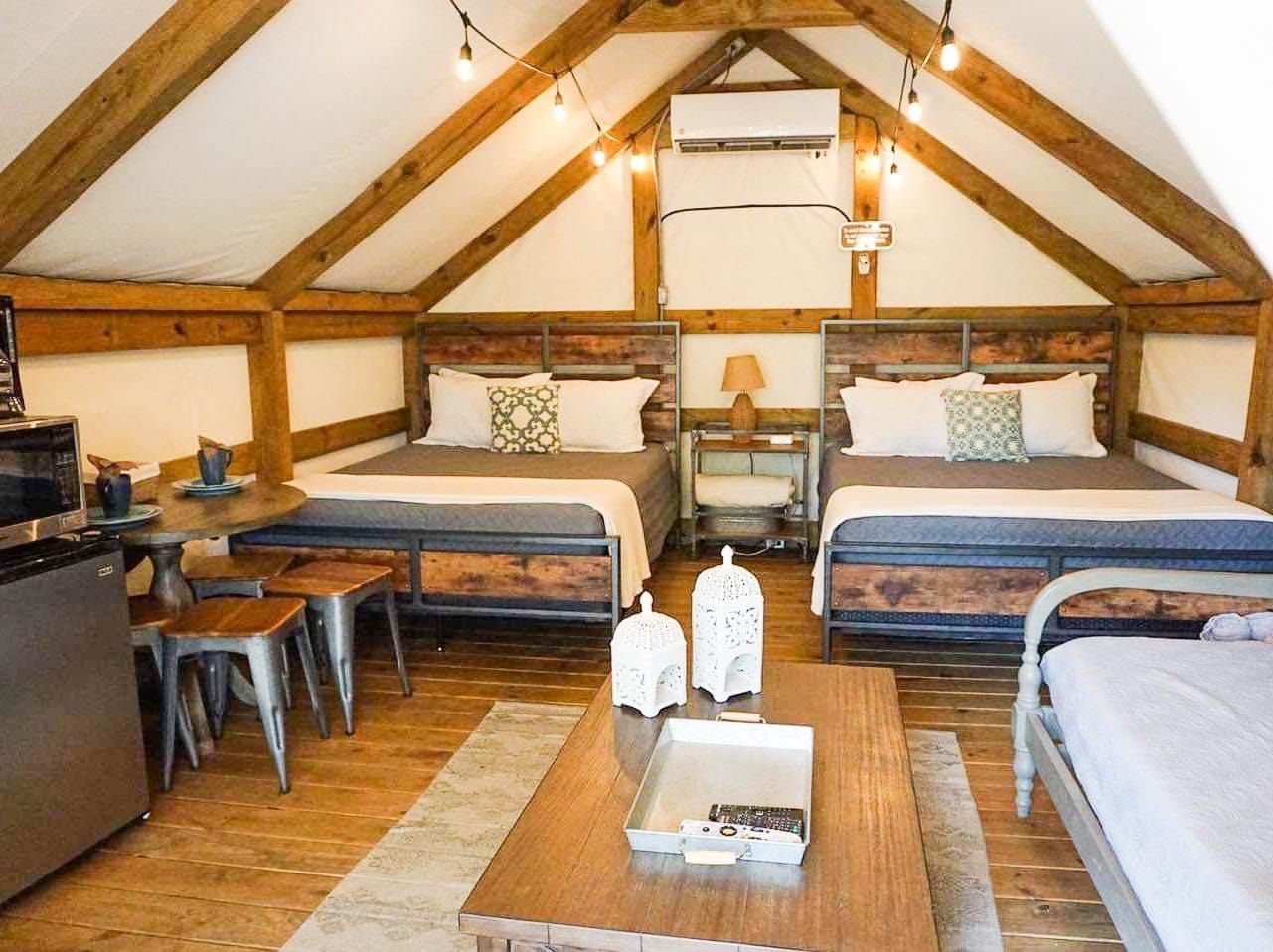 A bedroom with two beds , a coffee table , and a microwave.