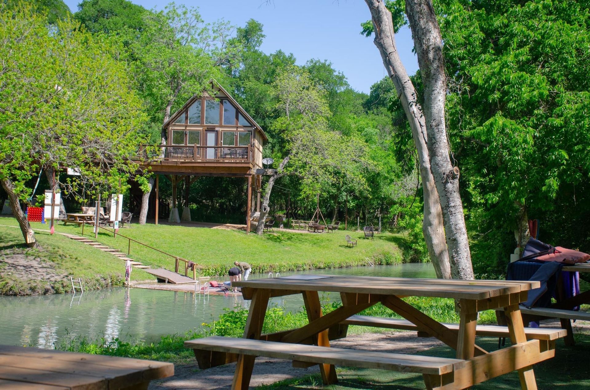 A picnic table in front of a house in the woods