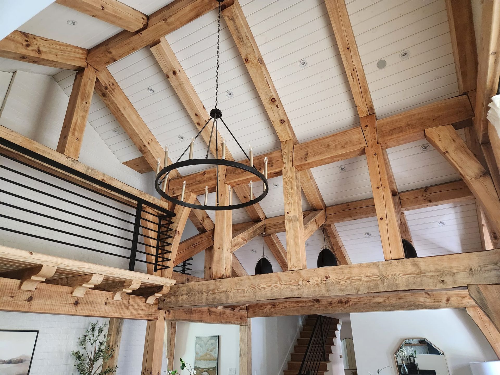 A living room with wooden beams and a chandelier hanging from the ceiling.