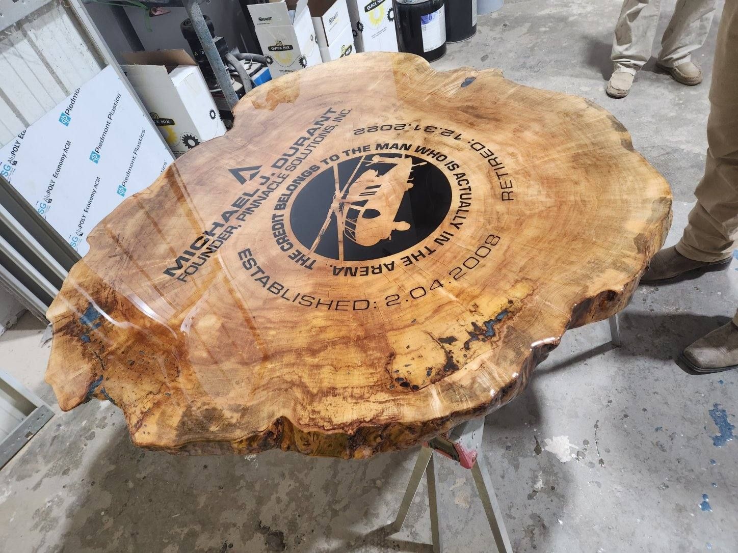 A large piece of wood with a logo on it is sitting on a table.