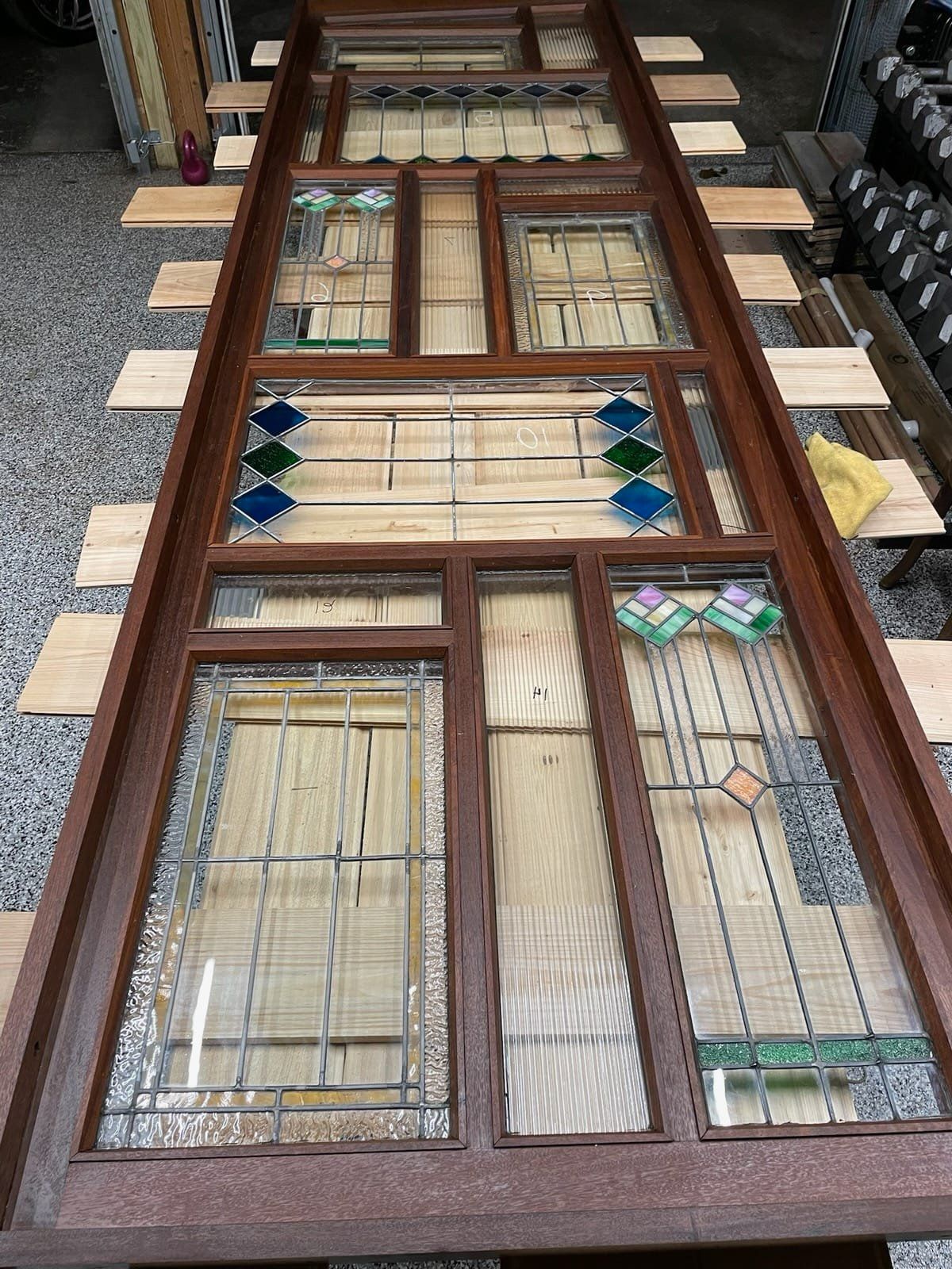 A stained glass window is sitting on top of a wooden table.