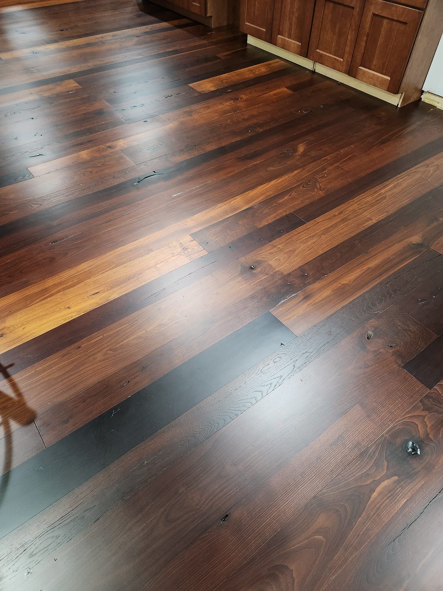 A close up of a wooden floor in a kitchen.